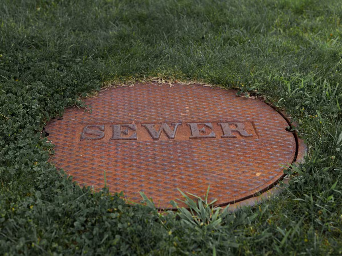 A cast sewer cover marking a buried line