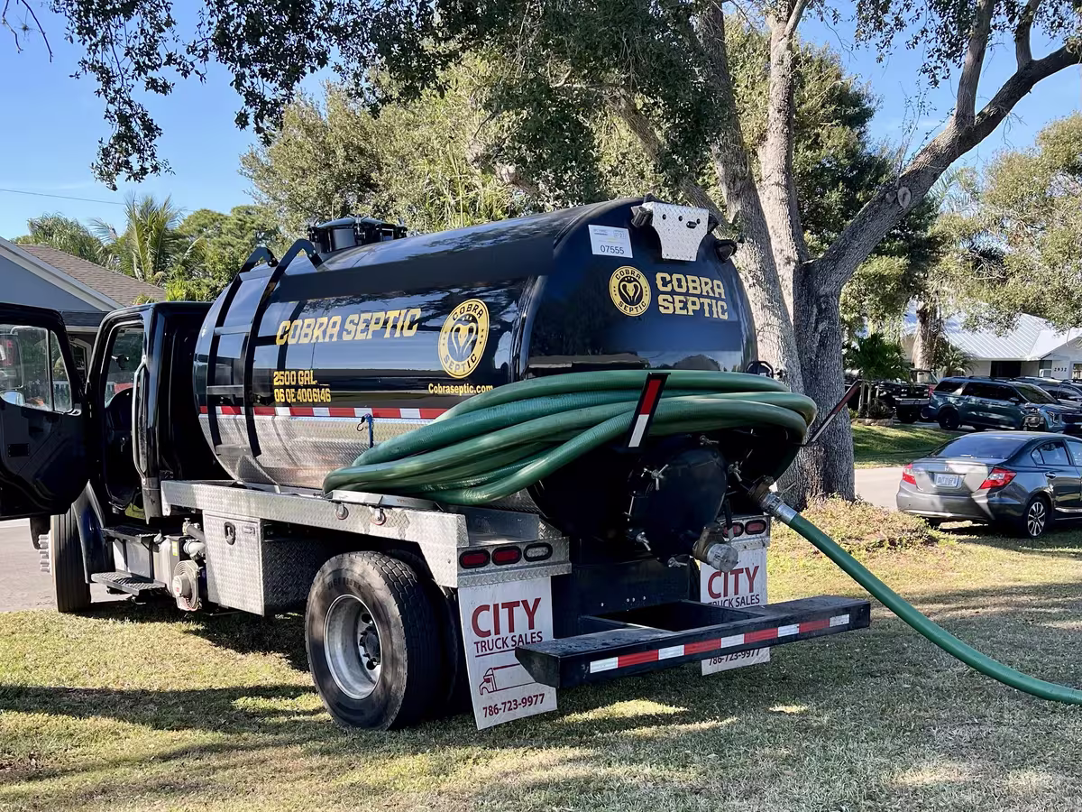 A Cobra Septic truck pumping a tank in a front yard
